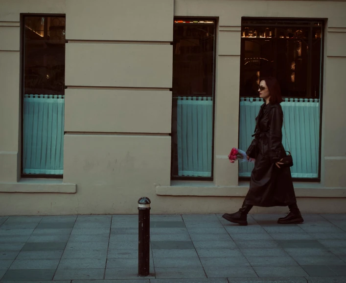 a woman walking down a street with a black jacket on