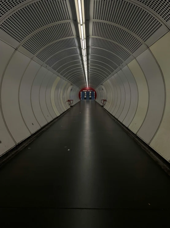 long tunnel leading up into a building with bright lights
