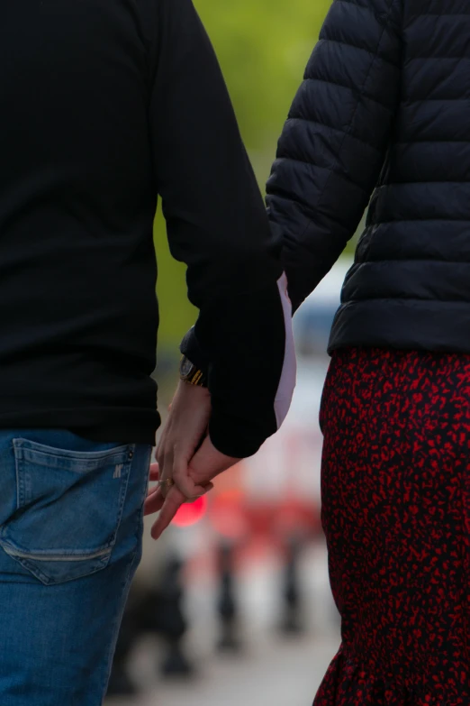 a couple holding hands as the guy walks with his wife in hand