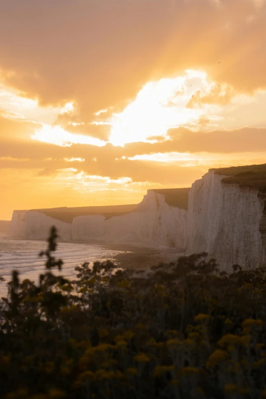 a white cliff overlooking the ocean at sunset