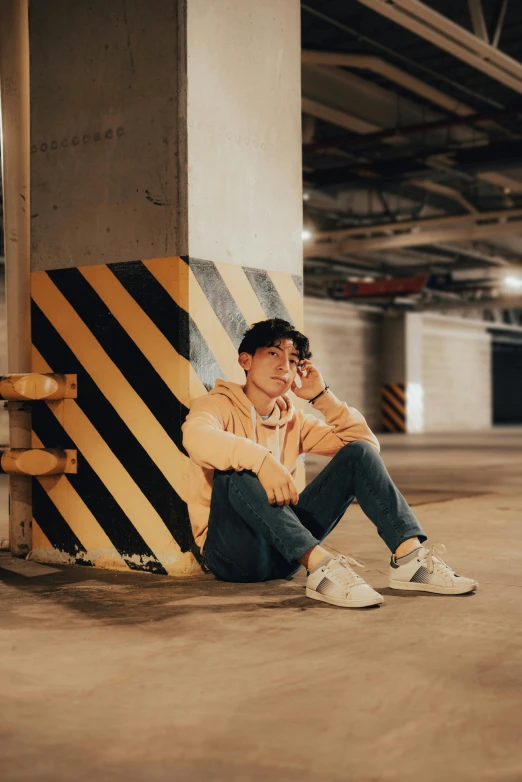 a man sitting on the ground next to a sign