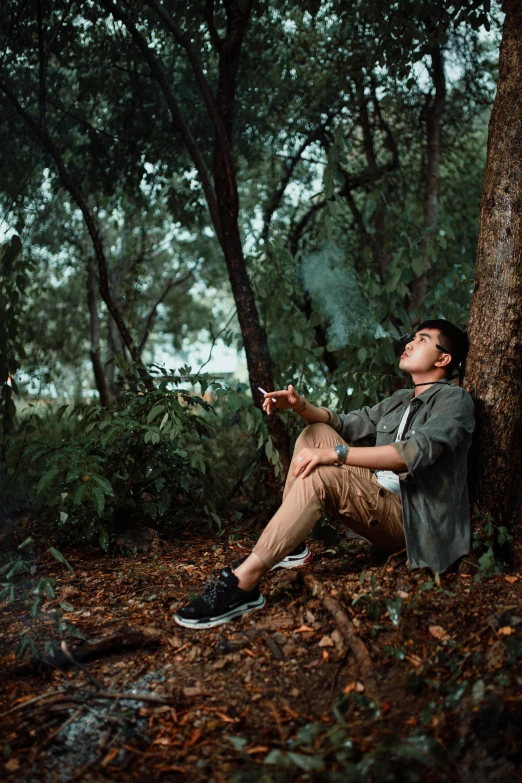 a man sitting on the ground with his eyes closed and holding soing