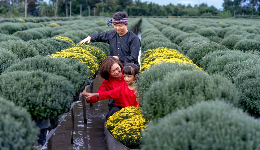 a man and two girls in a field of flowers