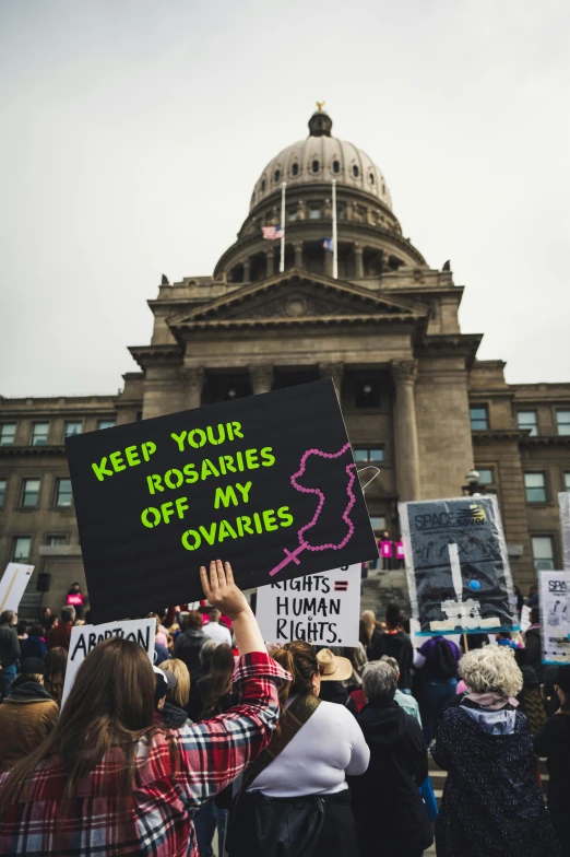 a group of people hold up signs outside a government building