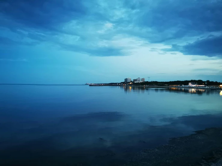 view from the beach at night with light houses in distance