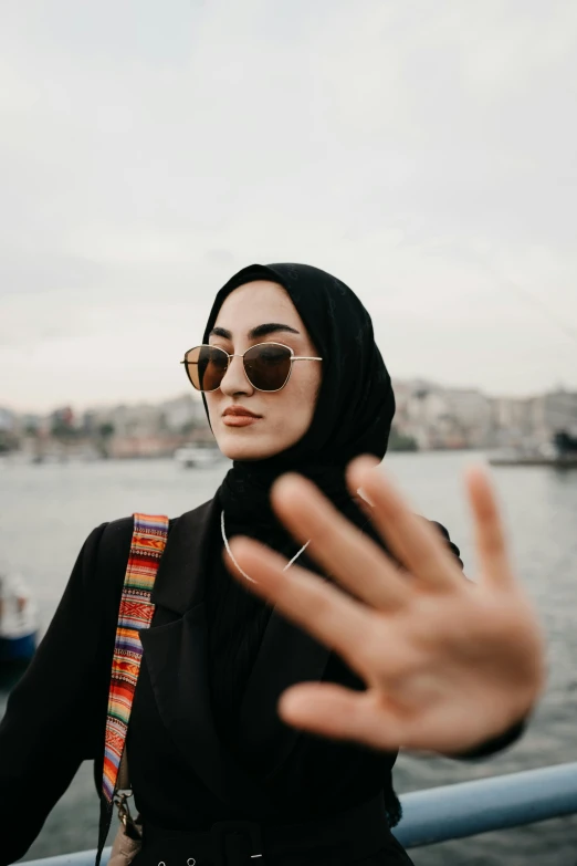 a woman in hijab and sunglasses taking a picture