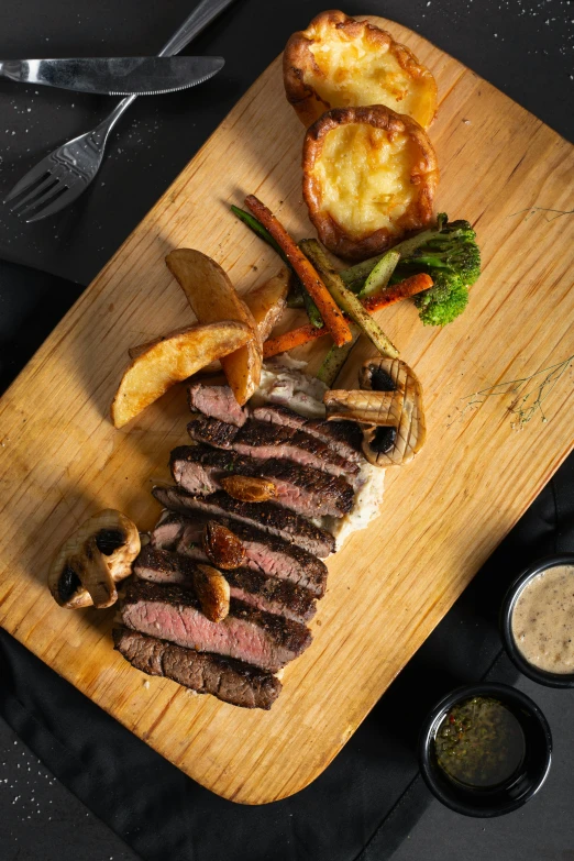 a wooden plate topped with slices of meat and vegetables