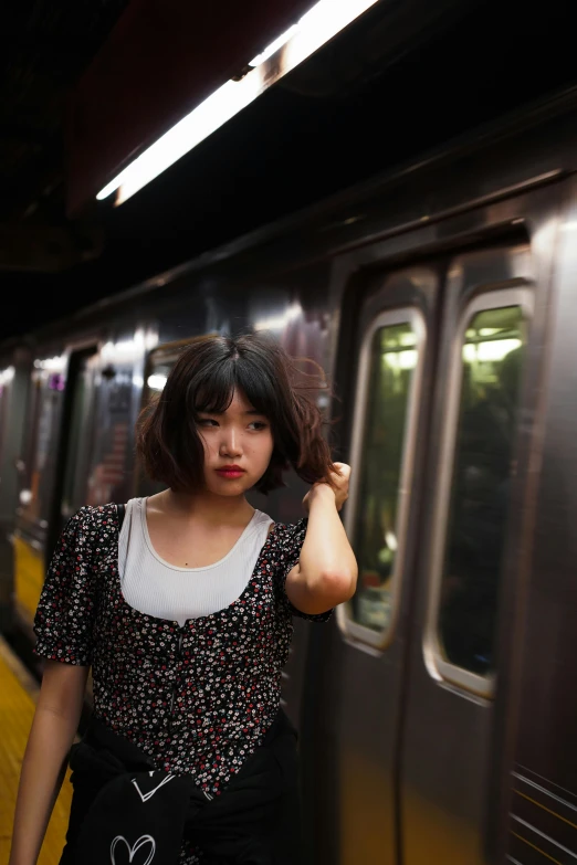 young asian woman waiting at the subway station