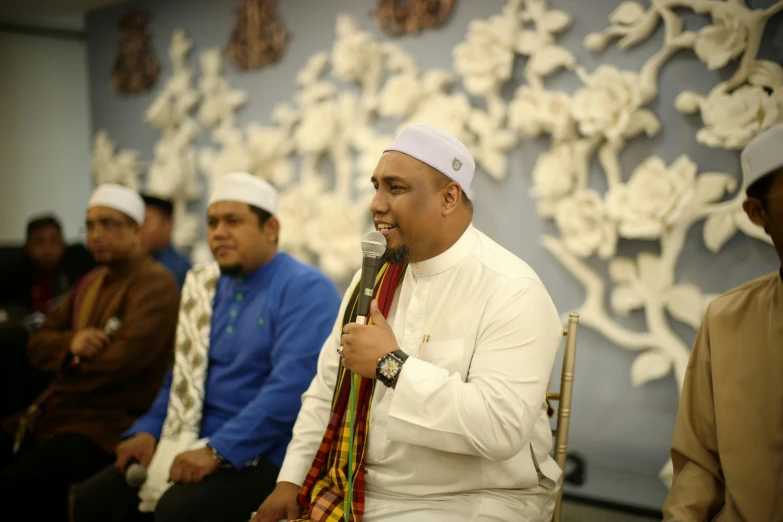 a man wearing a head scarf and holding a microphone