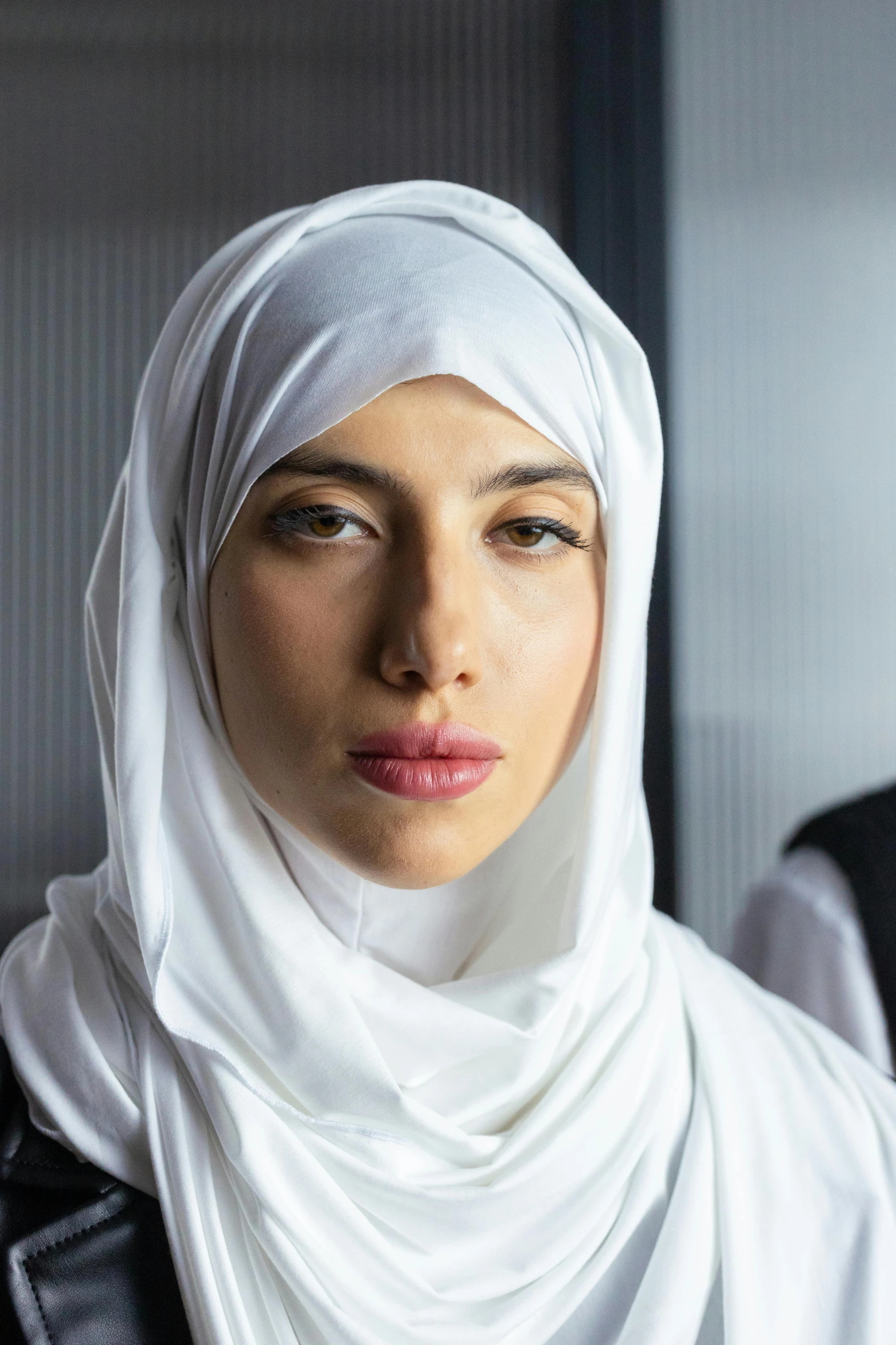 a woman wearing a headscarf looks up into the camera