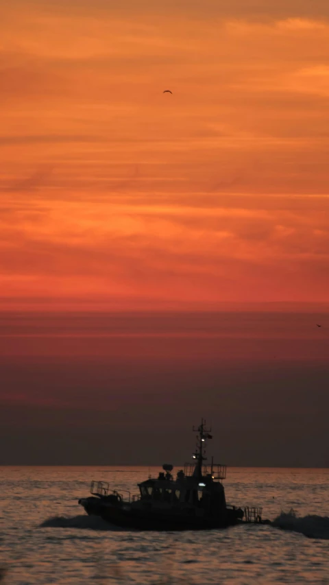 a boat is sailing through the water as the sun sets