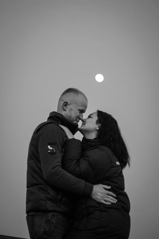 a man and woman kissing each other in black and white