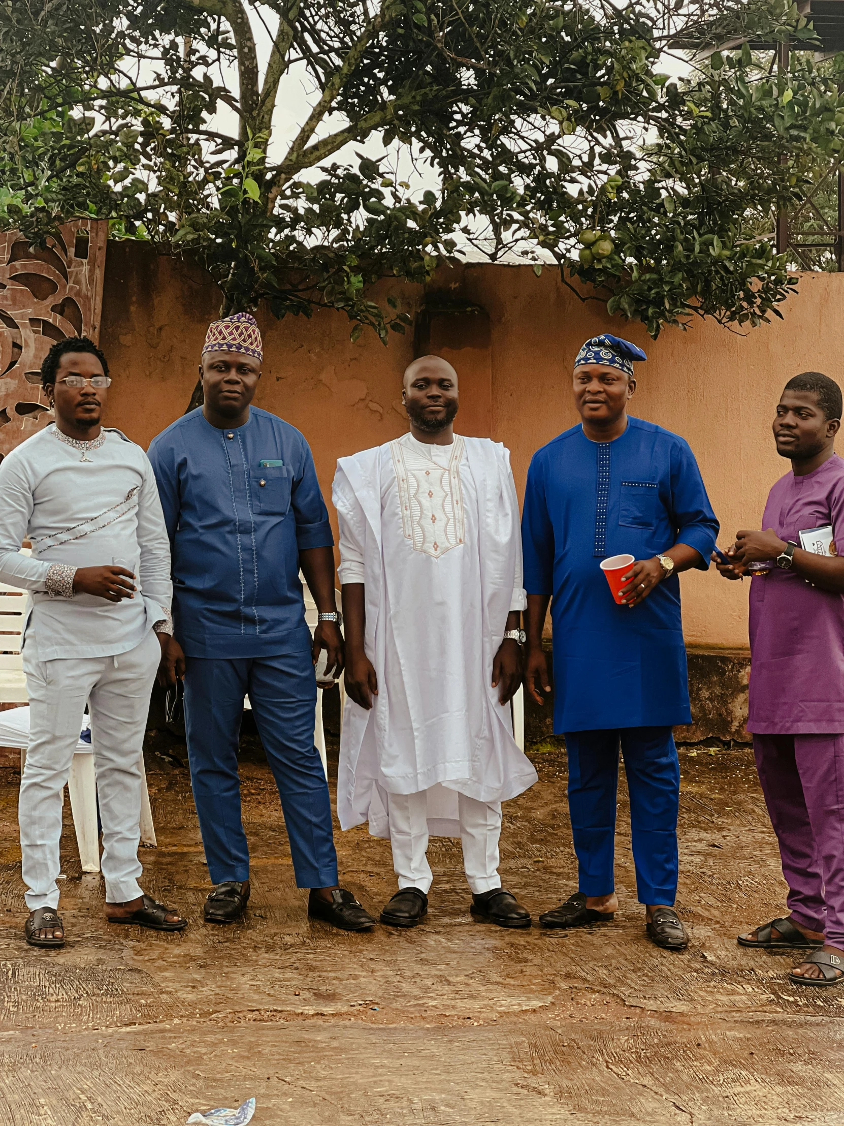 five men are standing around and posing for a picture