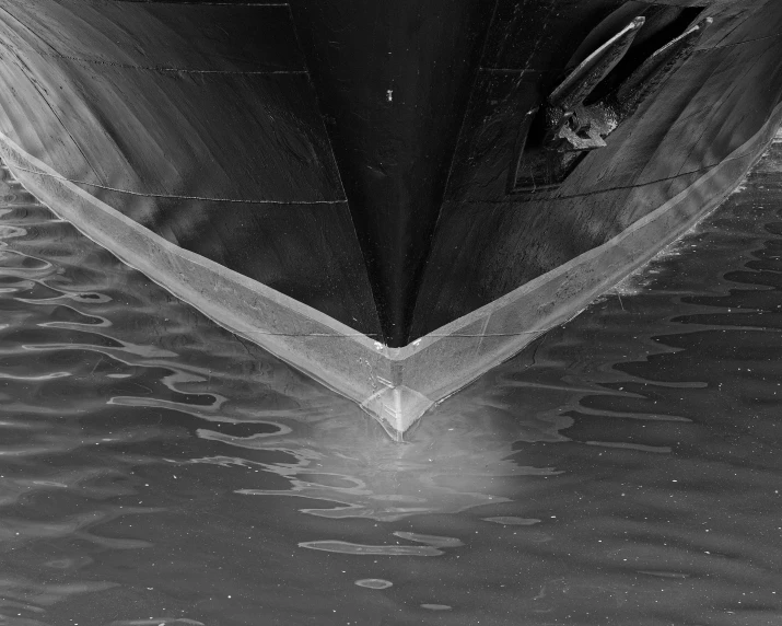 a boat is floating in the water in black and white