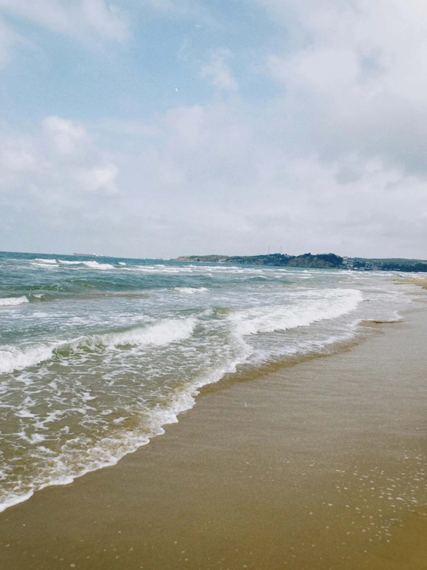 a view of an empty beach with the ocean in the distance