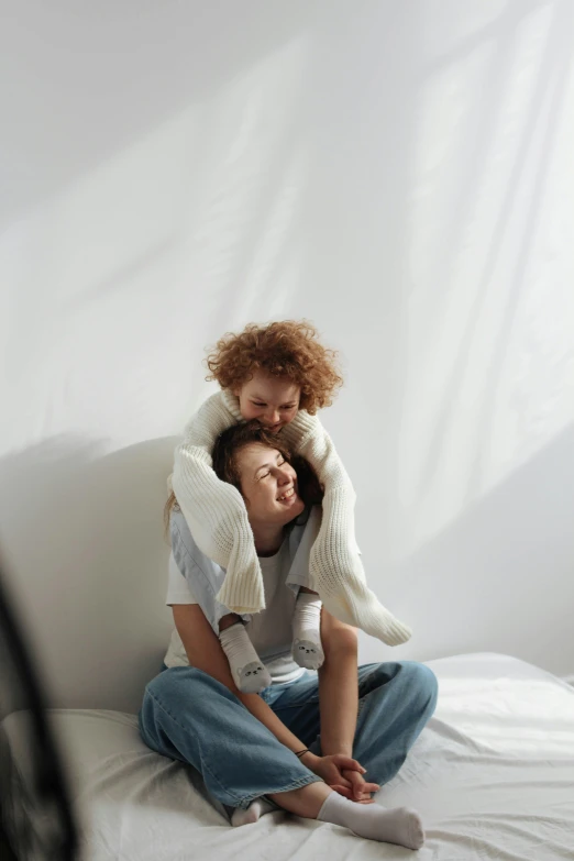 the young man and woman are sitting on a bed