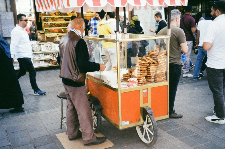 the man is buying bread on his street vendor cart