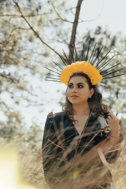 an image of woman with yellow headpiece standing in field