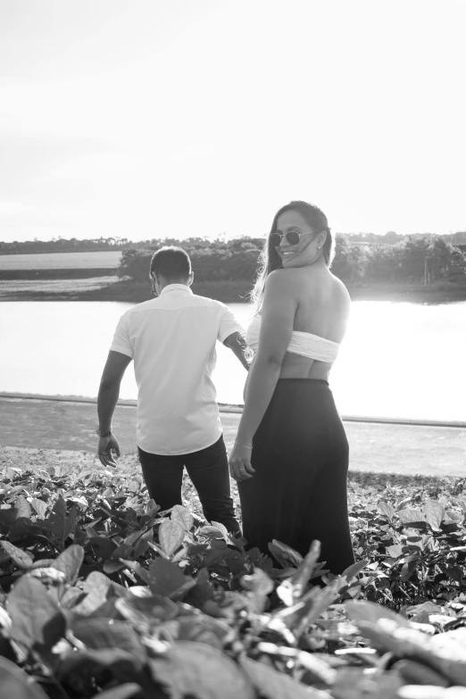 a couple standing next to each other near water