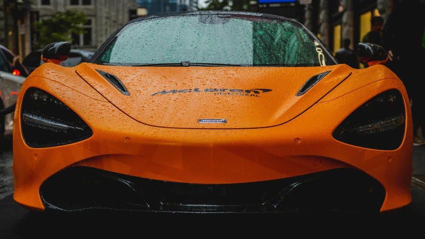 an orange sports car is sitting on the street