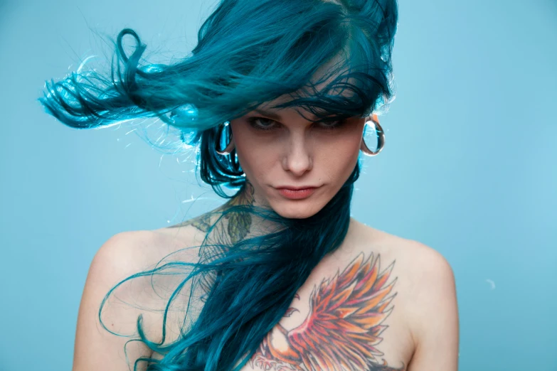 a woman with blue hair has an intricate tattoo