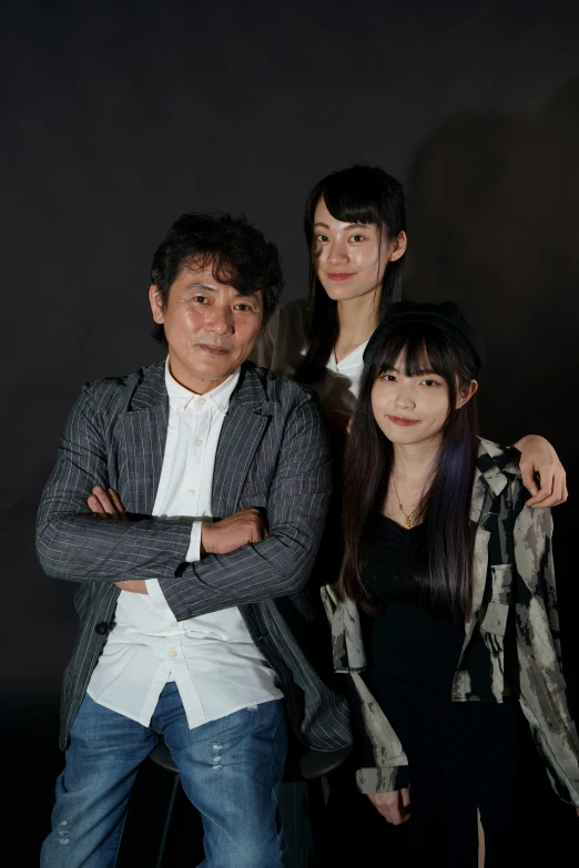 an asian family is posed together and smiling for a po