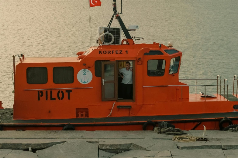 a boat sitting next to the water near a dock