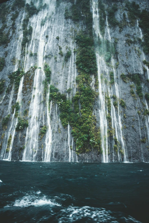 water cascading waterfall as it descends into the ocean