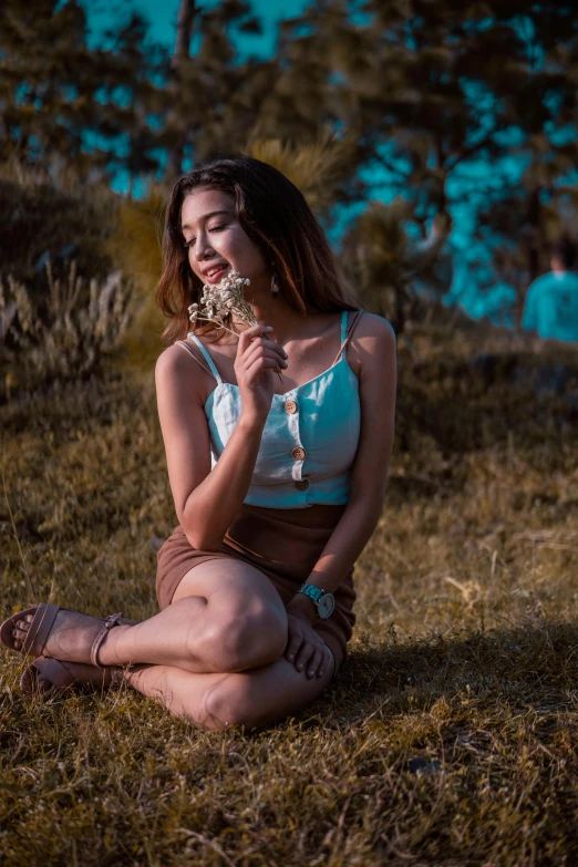 a woman sitting on the grass with some food