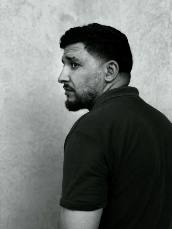 a young man with short hair and beard in black shirt