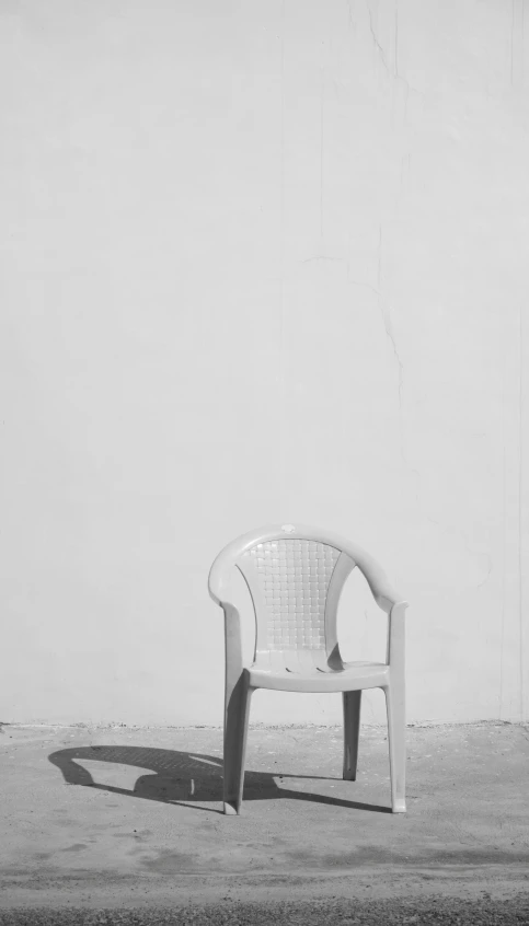 a white chair sitting on top of a cement field