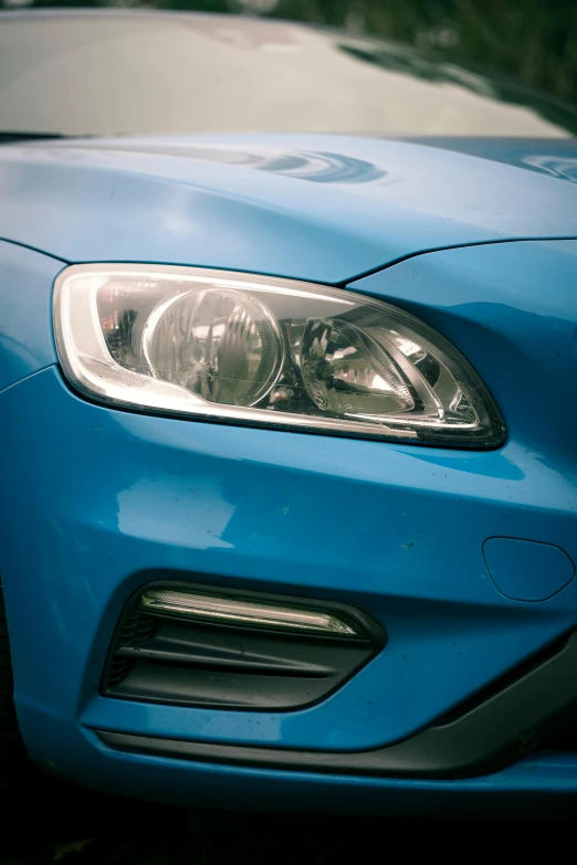 a close up of a blue car on a sunny day