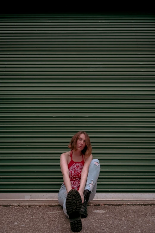 a person sitting on the ground and talking on a cell phone