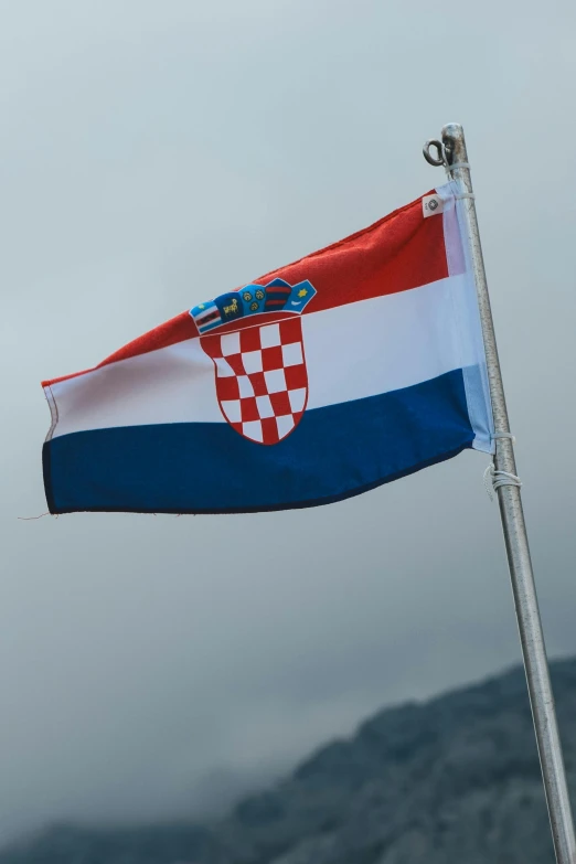 a flag on a pole in front of mountains