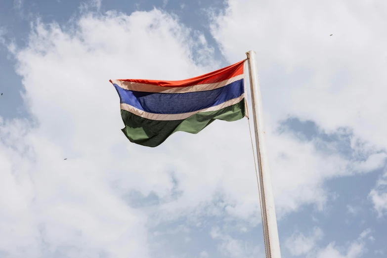 a multicolored flag flying from the top of a pole