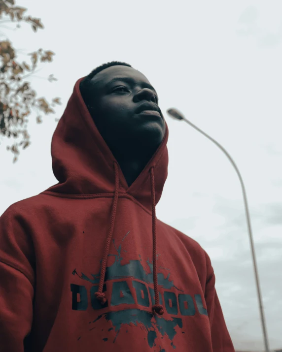 a man in red is looking up at a street light