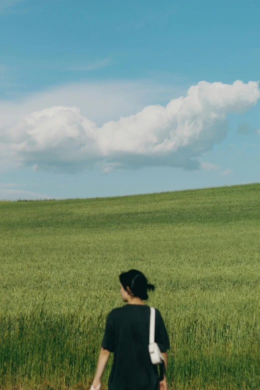 a woman stands on a field of wheat