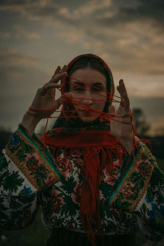 a woman holds up her head with string in it