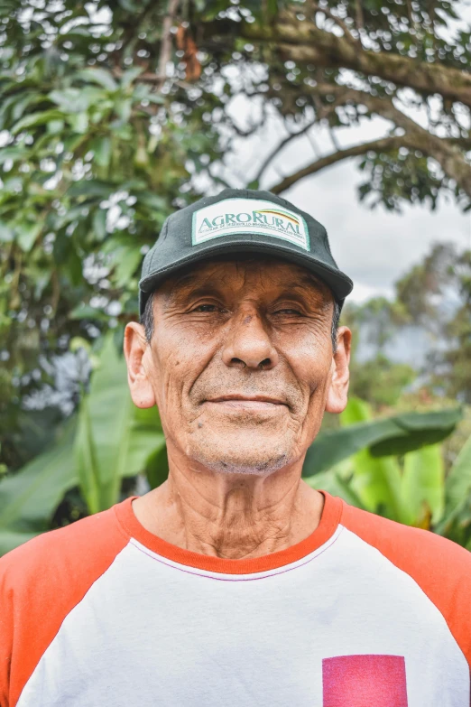 a man in an orange and white shirt with a hat on