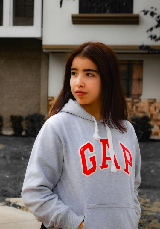 a girl in a sweatshirt poses for the camera