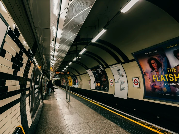 an empty subway station with lots of signs and advertits