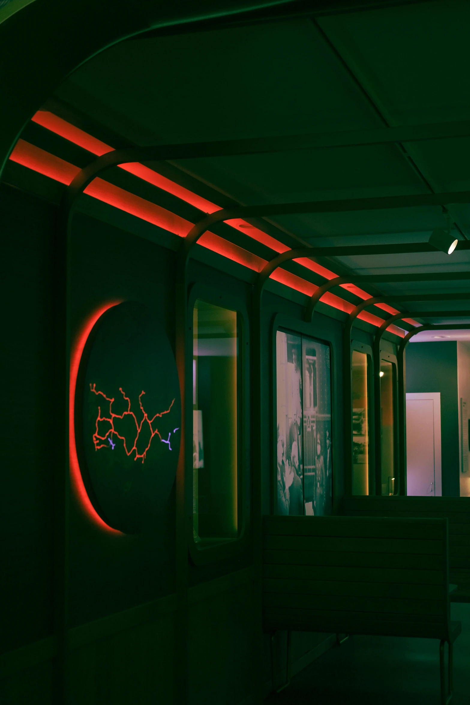 two chairs and tables with a neon light and artwork in background