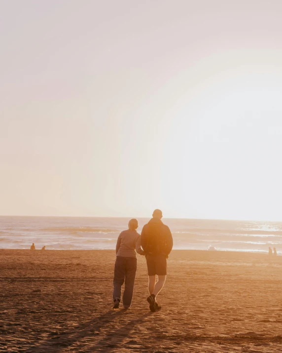 two people on a beach with kites flying in the sky