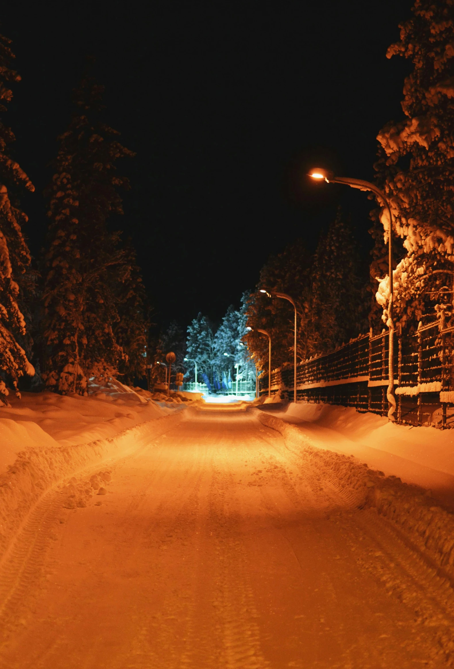 an empty street light shining on the snow