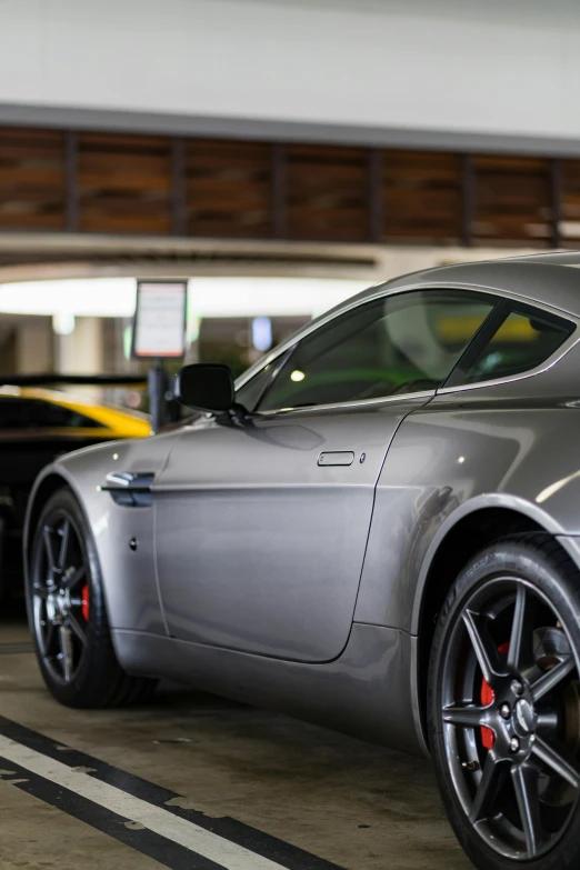 the front of the grey sports car is parked in the garage