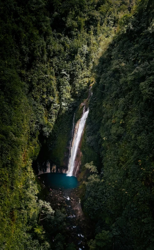 an aerial view of a waterfall surrounded by trees