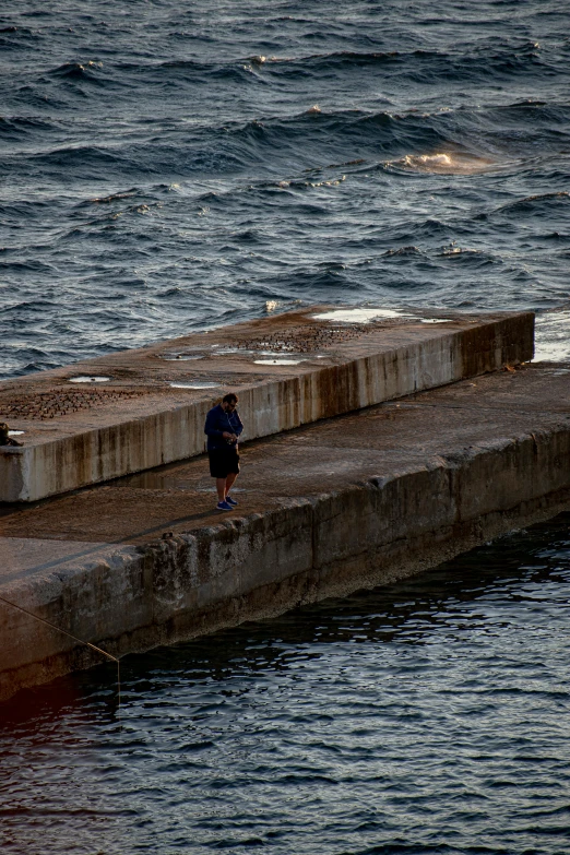 a man standing near the edge of a body of water