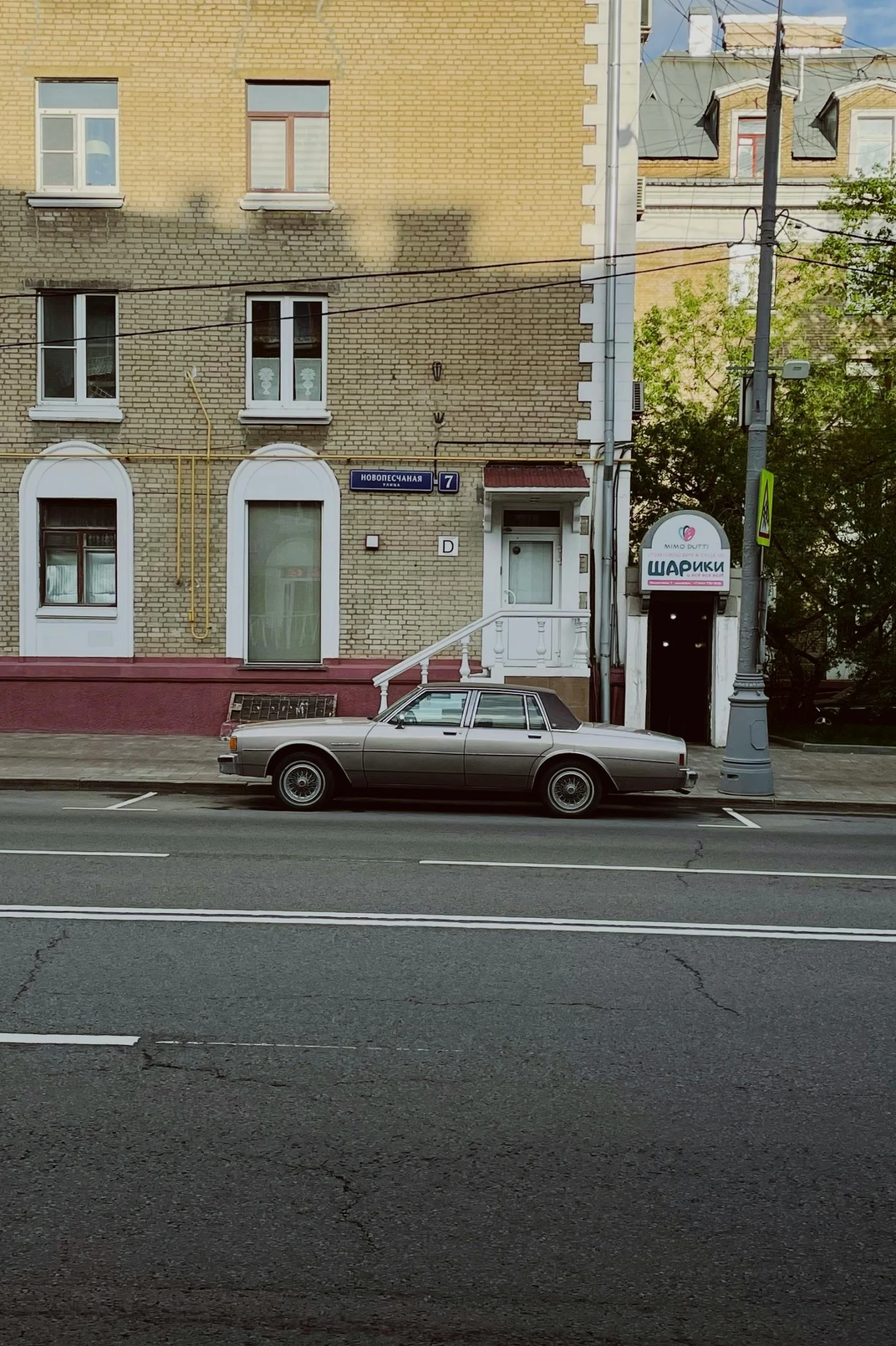 a street corner with a car parked near an apartment building