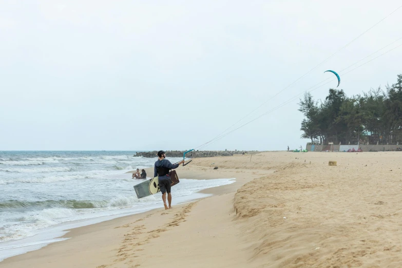 the man is walking on the beach with a surfboard