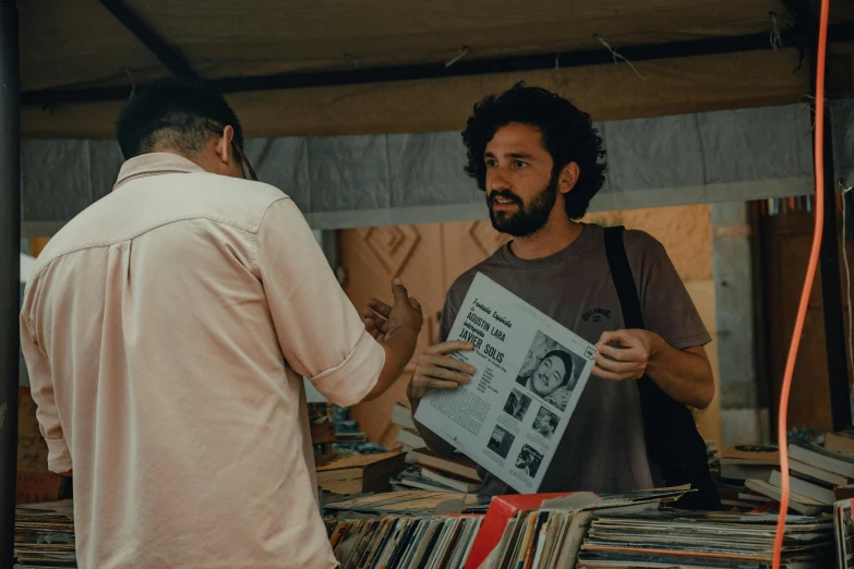 man holding a framed newspaper standing near another man